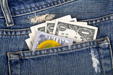 Sarı prezervatif ve bir mavi kot pantolon cebinde Amerikan Doları