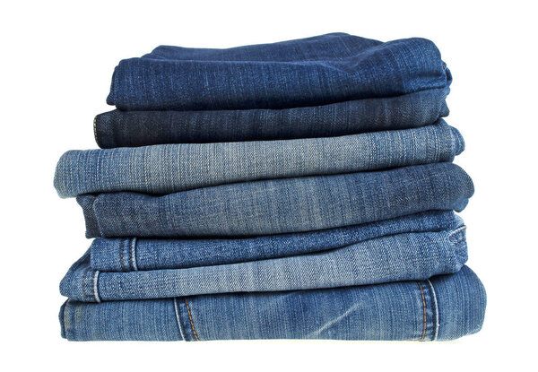 Lot of different blue jeans isolated on white background