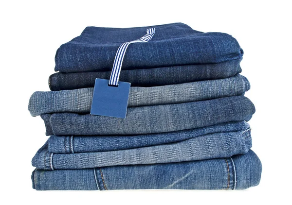 Un sacco di diversi blue jeans ed etichette isolate su uno schienale biancogr — Foto Stock