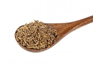 Tahta kaşık, beyaz bir arka plan üzerinde izole Kimyon tohumu