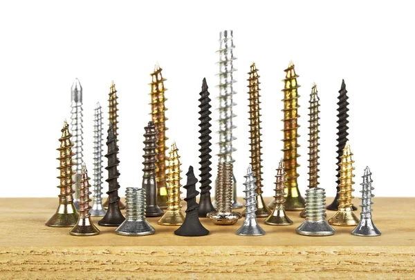 Beyaz bir arka plan üzerinde ahşap tahta üzerinde çeşitli vida