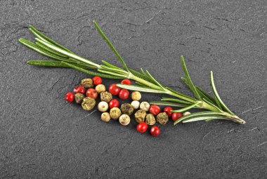 Taze biberiye bitki ve siyah arka plan üzerine karabiber. Culinar