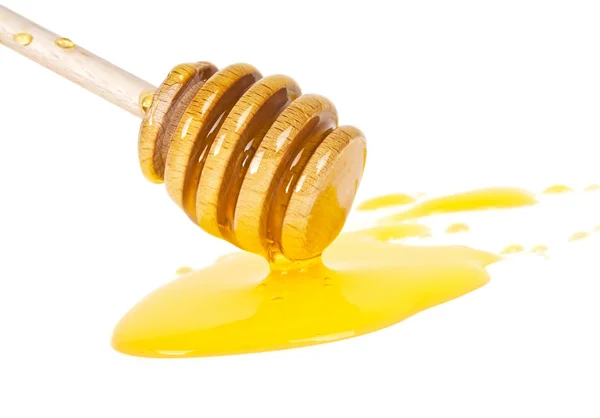 Μέλι που ρέει κάτω από ένα ξύλινο ραβδί που απομονώνονται σε λευκό backgro — Φωτογραφία Αρχείου