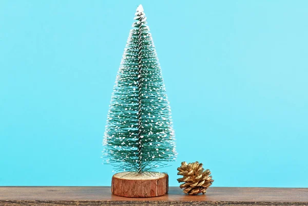 Χριστουγεννιάτικο δέντρο και χρυσό κουκουνάρι σε μπλε φόντο — Φωτογραφία Αρχείου