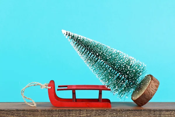 Χριστουγεννιάτικο δέντρο και κόκκινο έλκηθρο σε μπλε φόντο — Φωτογραφία Αρχείου