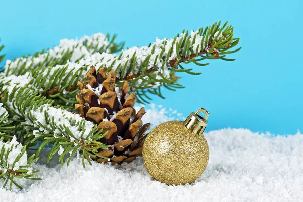 Υποκατάστημα της χριστουγεννιάτικο δέντρο, κουκουνάρι και Χριστουγεννιάτικη μπάλα στο χιόνι o — Φωτογραφία Αρχείου