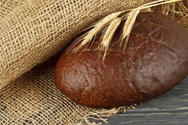 Brot und Ohren auf hölzernem Hintergrund — Stockfoto