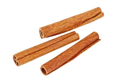 Beyaz arka planda üç tarçın çubuğu.