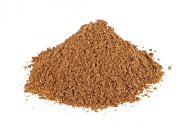 Beyaz bir arka plan üzerinde kişniş toz yığını