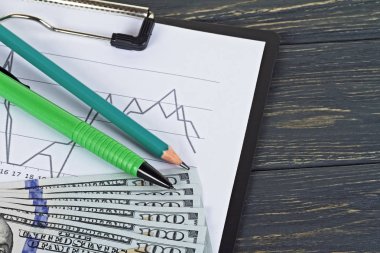 Amerikan Doları, kalemler ve ahşap arka plan üzerinde grafik