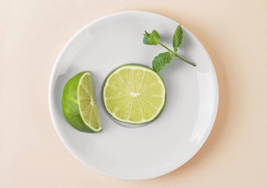 Taze limon nane ile beyaz plaka üzerinde bırakır. Bej renkli arka plan.