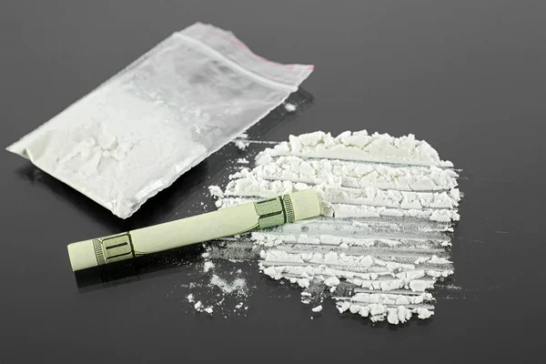 Yüz dolarlık banknot ve kokain uyuşturucu tozu siyah silindir — Stok fotoğraf