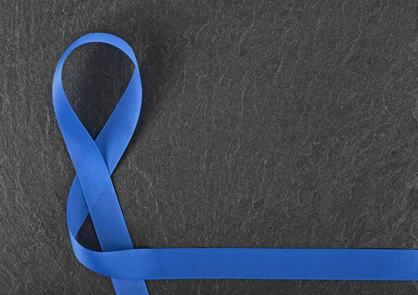 Kolon kanseri farkındalığı - Siyah üzerine mavi kurdele. — Stok fotoğraf