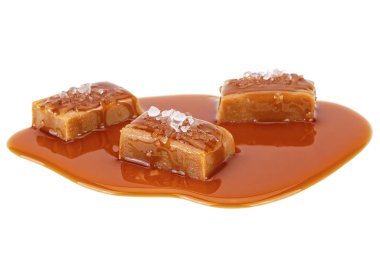 Karamel soslu tuzlu karamel şekerlemeleri beyaz sırtında izole edilmiş.