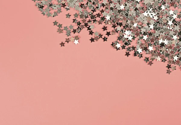 Silver glitter stars on pink background. Festive holiday pastel