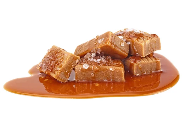 Delicious candies with caramel sauce and salt isolated on a whit — Stockfoto