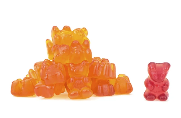 stock image Heap of orange jelly bears candies and one red bear isolated on a white background. Gummy bears