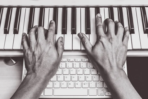 Composer hands working on piano keys & computer keyboard — Stock Photo, Image