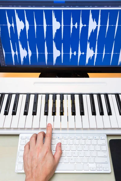 Composer hands working on piano keys & computer — Stock Photo, Image