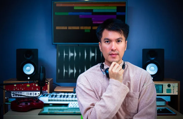 Asian handsome sound engineer posing in digital recording, editing, broadcasting studio. music, tv, radio, advertising, jingle, post production technology Royalty Free Stock Photos
