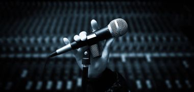 singer hands holding microphone on studio mixer background clipart