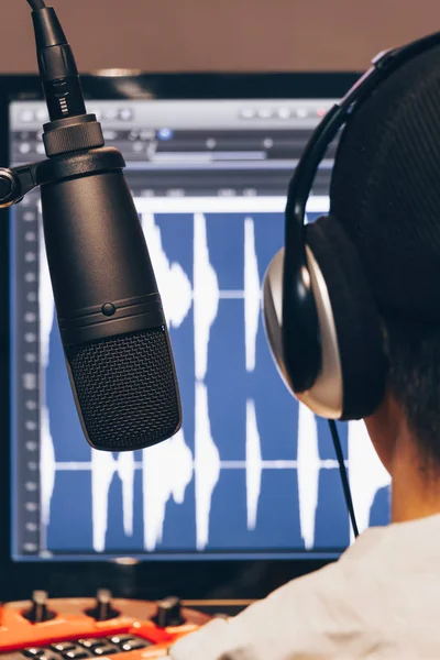 Back of male asian DJ working in digital broadcast studio — Stock Photo, Image