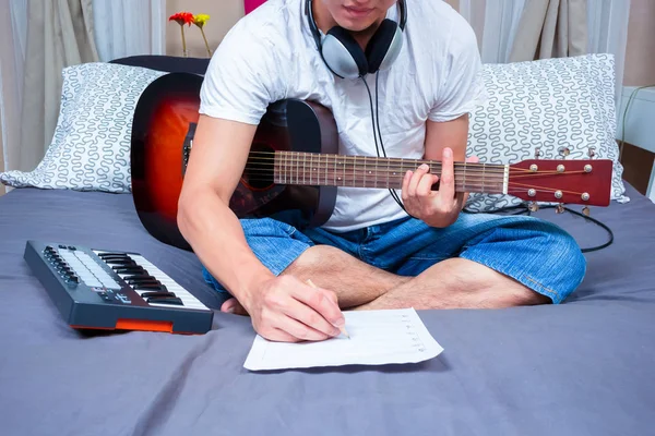 Asiático masculino compositor, músico escritura canción & jugando guitarra en cama —  Fotos de Stock