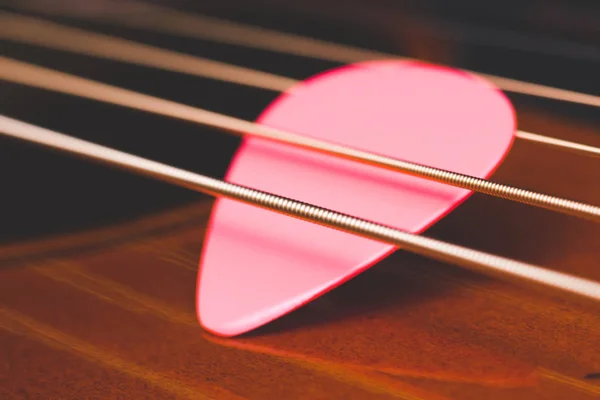 Akustik Gitar telleri, pembe pick alan sığ bölümü — Stok fotoğraf