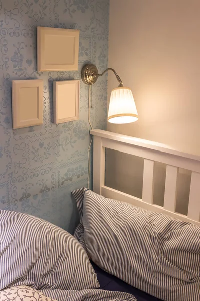 wall lamp over bed, cozy bedroom
