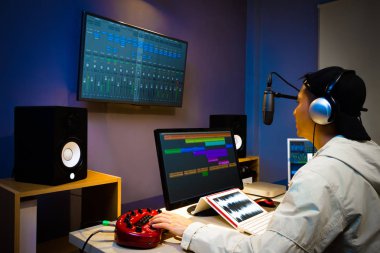 Asyalı erkek Dj çalışma dijital yayın studio, online radyo istasyonu, podcast, sonrası üretim teknolojisi