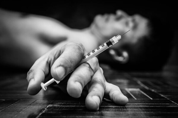 syringe in overdose asian male drug addict hand