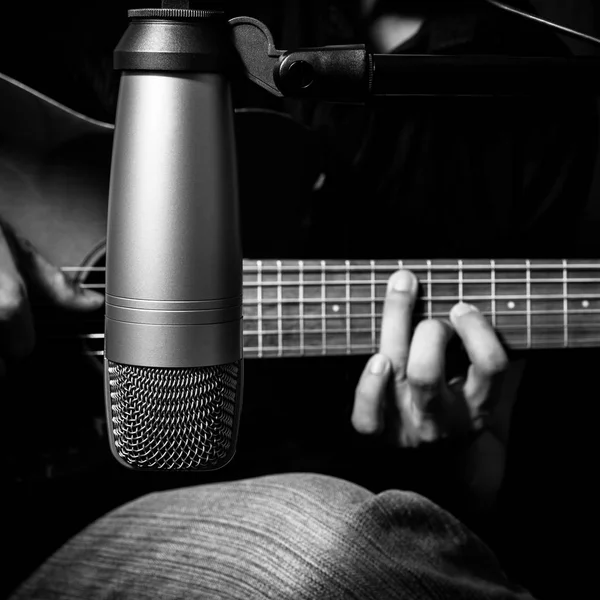 Erkek müzisyen kayıt stüdyosunda Kondenser mikrofon arkasında akustik gitar çalmak — Stok fotoğraf