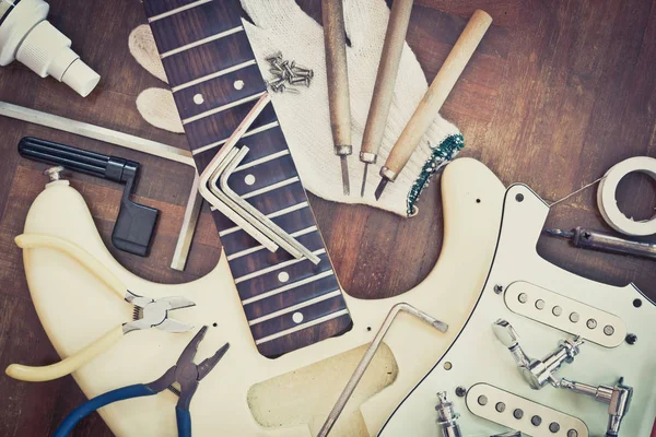 Gelbe E-Gitarre auf Holz in Reparatur- & Geigenbauwerkstatt, Reparaturkonzept für Reparaturen von Musikinstrumenten — Stockfoto