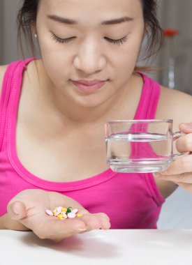 Asyalı güzel kadın tablet, ilaç, uykusuzluk, ateş ve baş ağrısı acı su ile