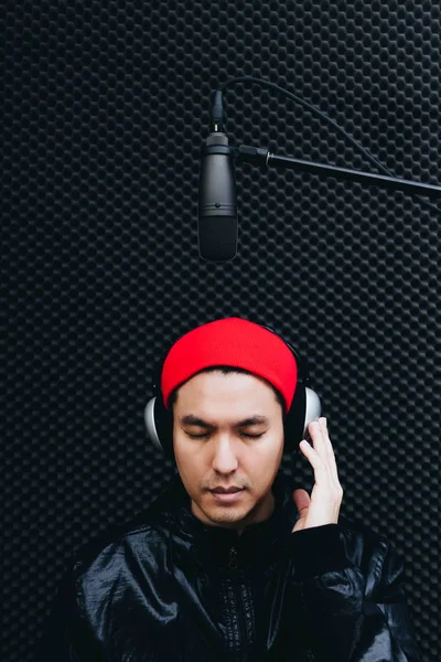 asian handsome voice actor, singer concentrate in recording studio for music or post production background