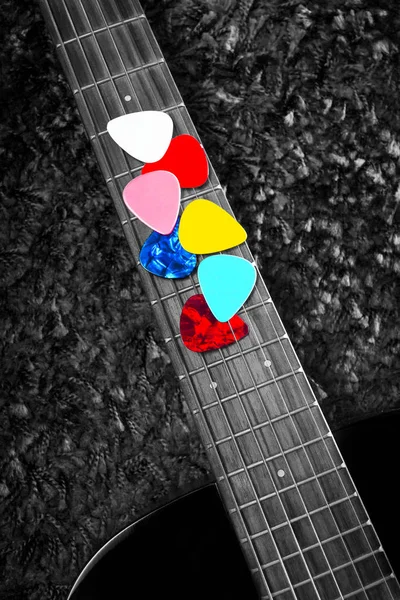 Picaretas coloridas na guitarra acústica fingerboard — Fotografia de Stock