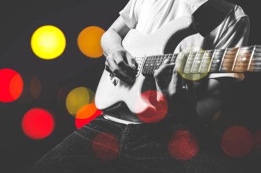 Asya müzisyen elektro gitar renkli bokeh ışık ile sahnede çalmak