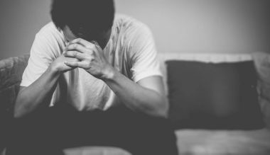 koltukta oturan çaresiz Asya adam. hissediyorum üzgün, baş ağrısı, geceleri yalnız