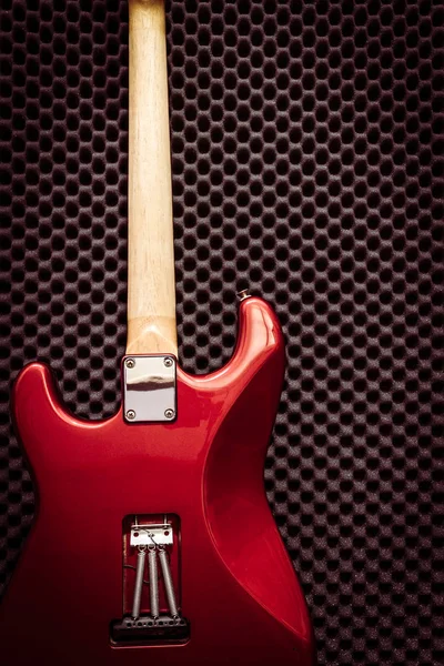 Kırmızı elektrik gitarda arkasında siyah akustik yönetim kurulu müzik arka plan için kayıt stüdyosu — Stok fotoğraf