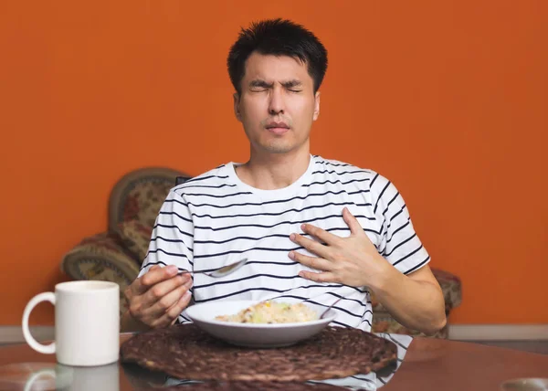アジア人男性は食べながら心臓発作の症状をします。 — ストック写真