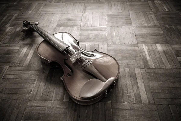 Violino clássico vintage no chão de madeira para fundo de música — Fotografia de Stock