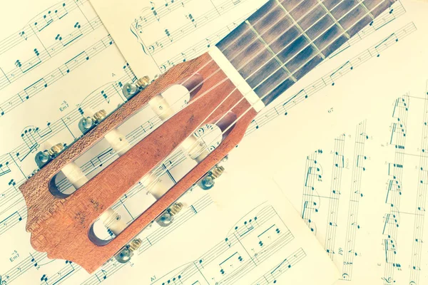 Tête de guitare acoustique sur feuille de musique — Photo