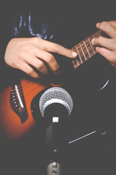 musician hands playing & recording acoustic guitar