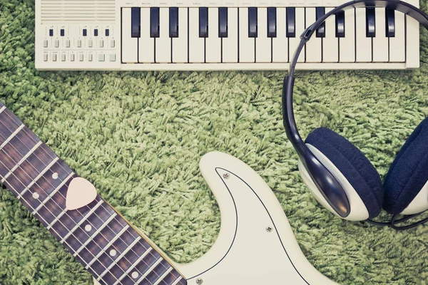Photo rétro de guitare électrique, casque & clavier de musique, piano sur vert — Photo