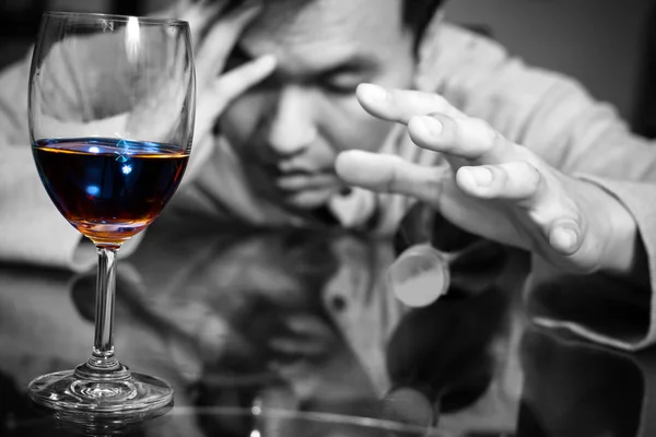 Dronken, eenzame Aziatische man met glas en whiskey wijnfles — Stockfoto