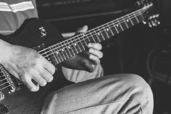 musician hands playing electric guitar, black and white