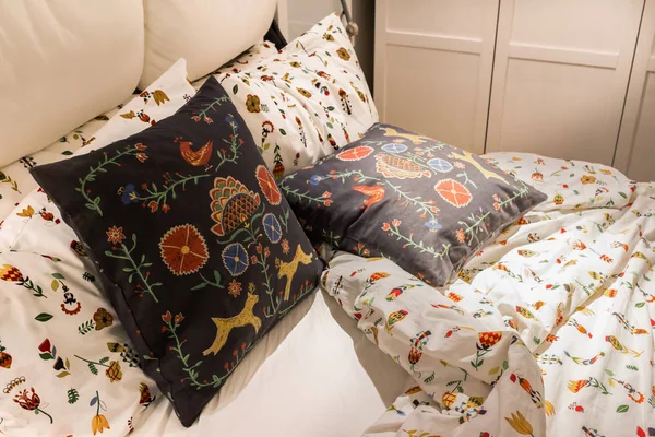 Cojín patrón de flores y almohada en la cama en el dormitorio acogedor —  Fotos de Stock