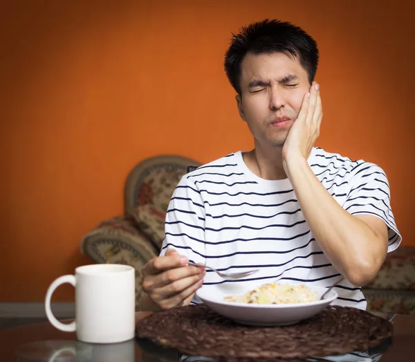 Asian man has a hypersensitive teeth and toothache while eating — Stock Photo, Image