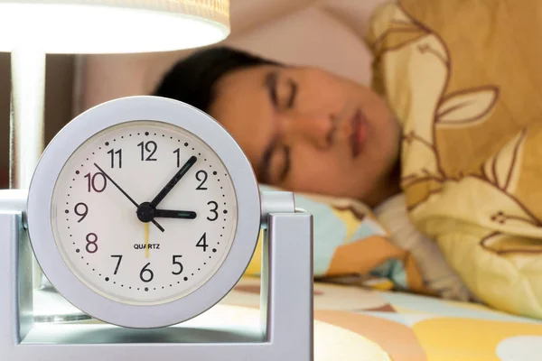 Schlafender asiatischer Mann mit Uhr nachts — Stockfoto