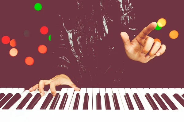 Compositor profissional tocando piano branco com fundo bokeh colorido — Fotografia de Stock